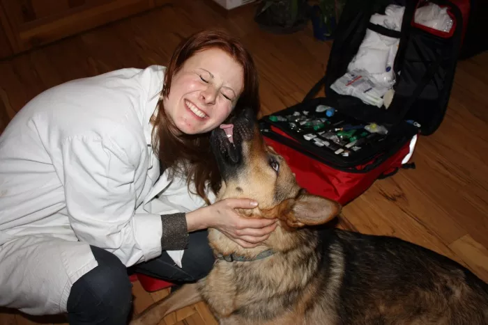 pes veterinářce dává pusu olizuje jí ucho